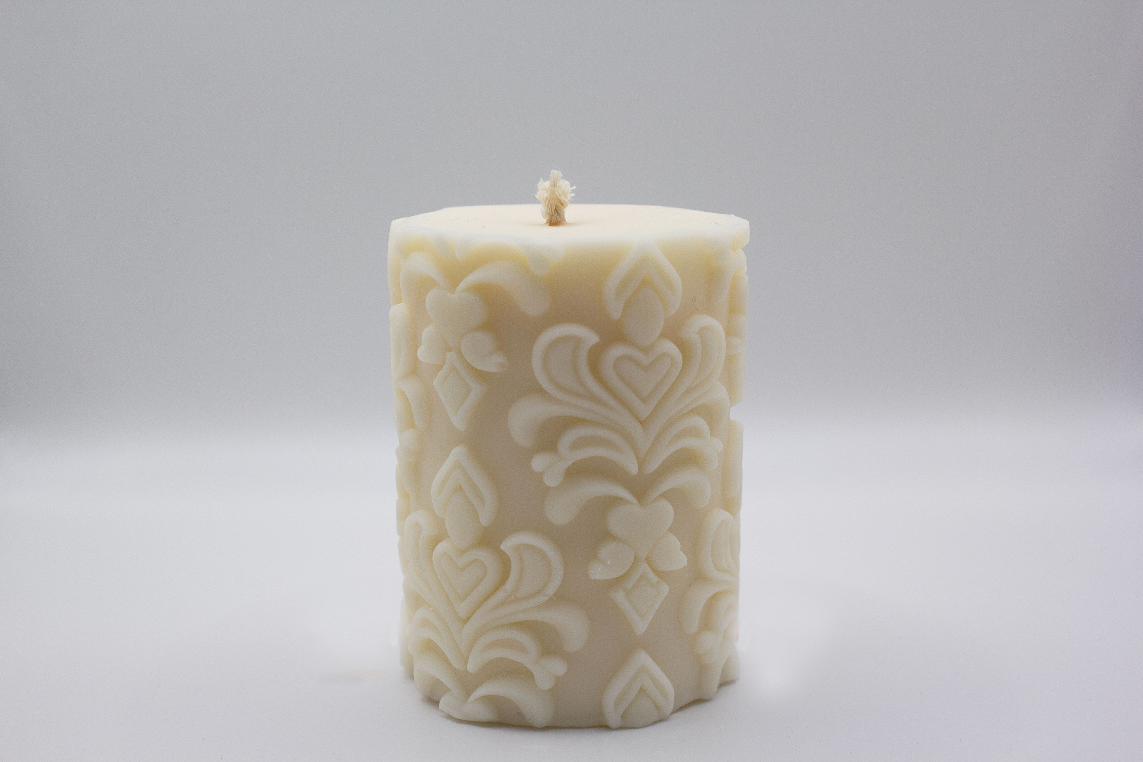Bougie pilier aux motifs ornementaux en relief