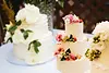 Plusieurs gâteaux de mariage personnalisés décorés de fleurs fraîches