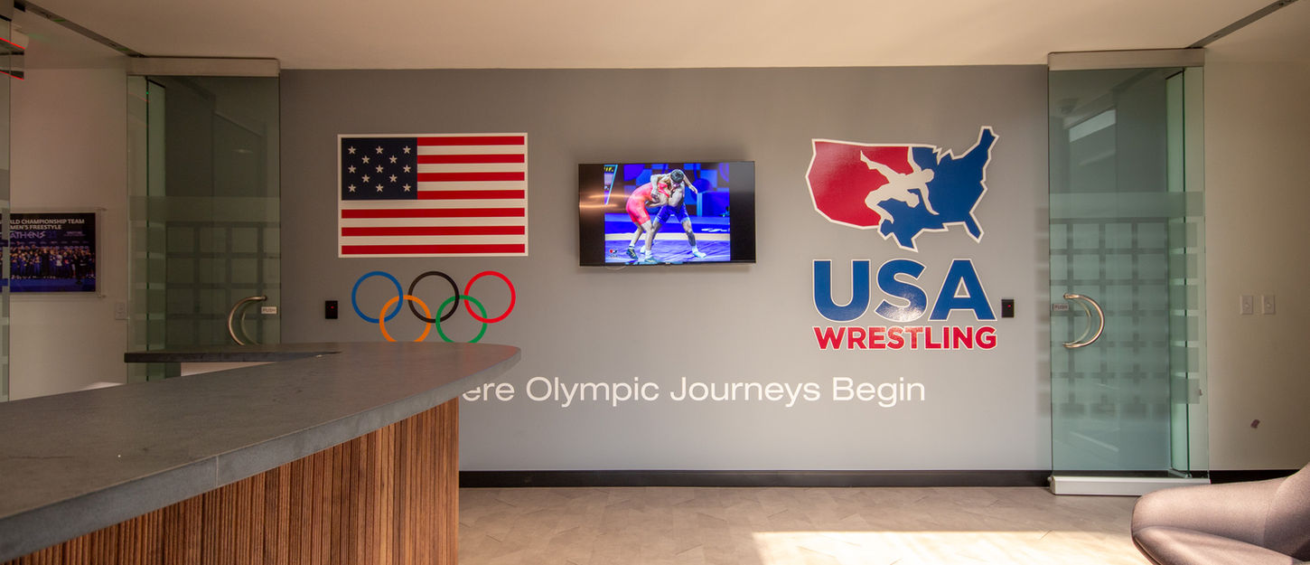 Presentation room with organization branding on the wall, an American flag graphic, and seating area.