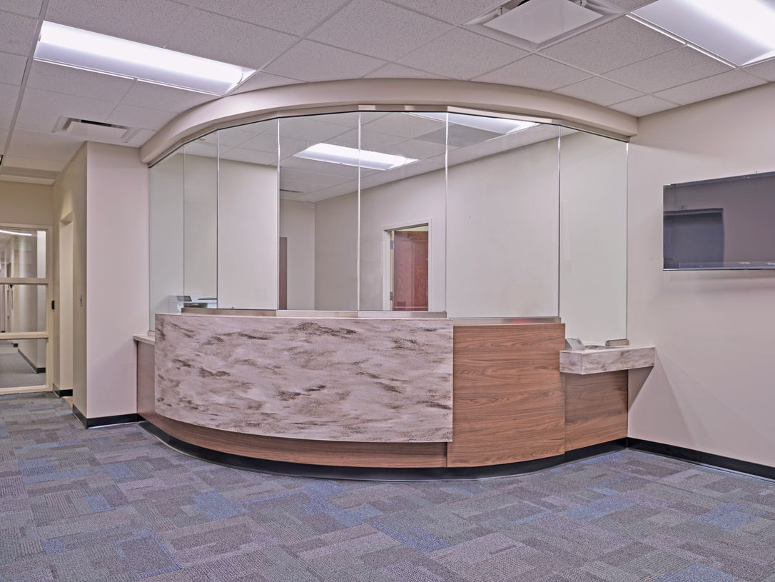 New renovated reception desk at El Paso County Department of Public Works, showcasing security features and modern interior design.