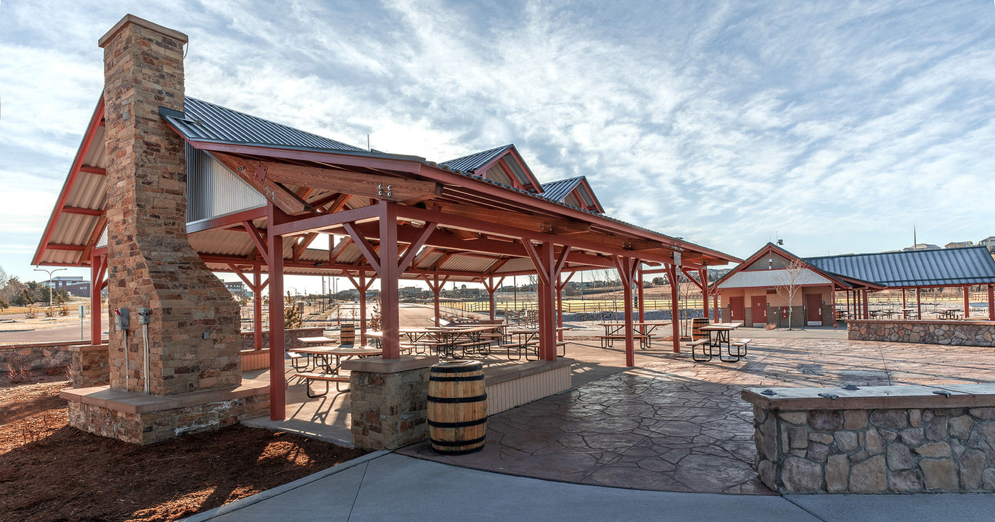 Architect-designed steel canopy pavilion in a city park with modern landscaping