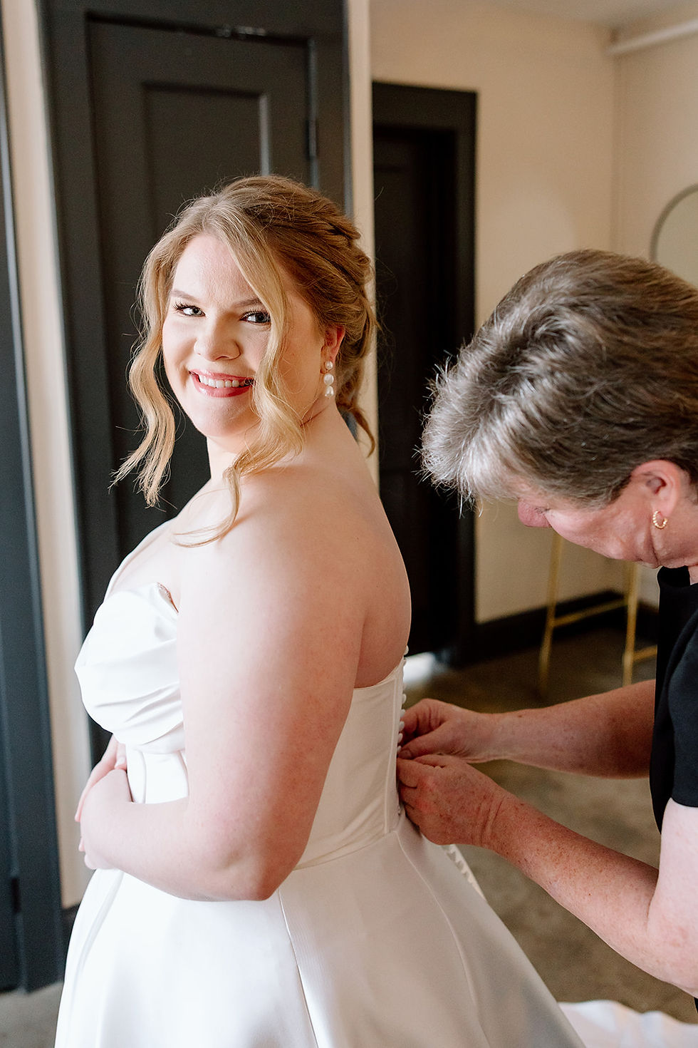 Emily smiles as she finishes getting ready before her intimate wedding ceremony at The Fire House KC in Kansas City.