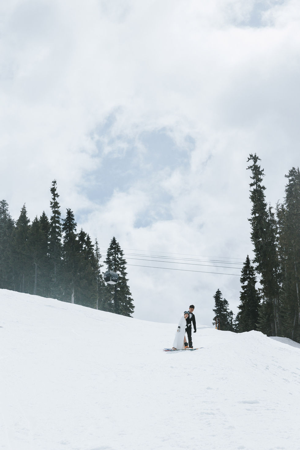  Engaged couple riding their snowboards down the slopes side by side at Whistler Blackcomb — adventurous and joyful winter engagement moment.​​​​​​​​​​​​​​​​