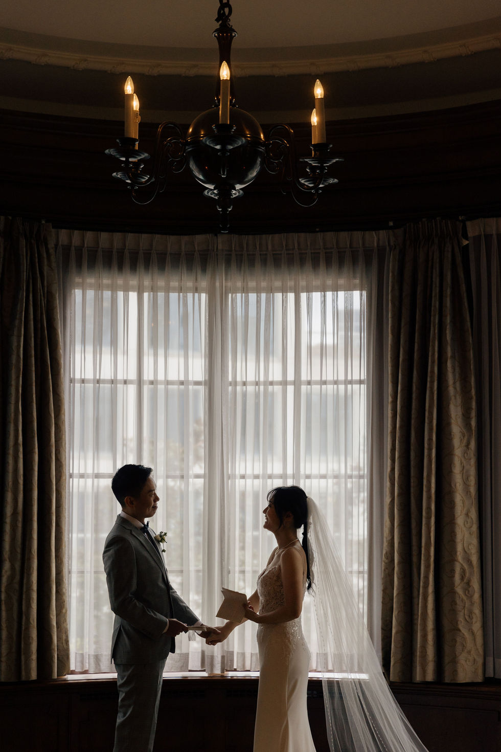  Bride and groom holding hands and gazing deeply into each other’s eyes at Hotel Georgia in Vancouver — intimate and tender private vow exchange moment.​​​​​​​​​​​​​​​​
