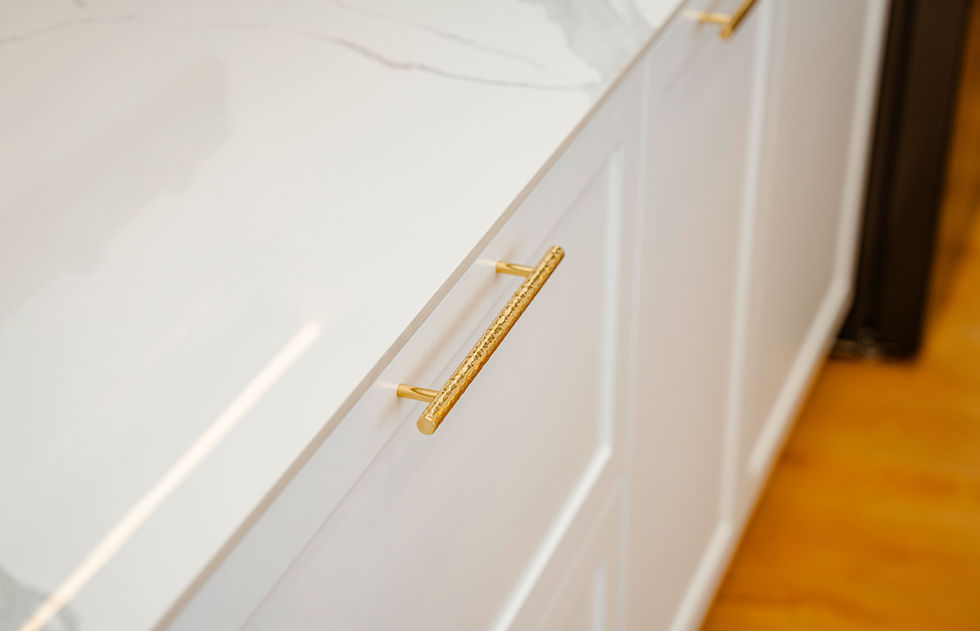 a shiny white counter with a gold pull drawer