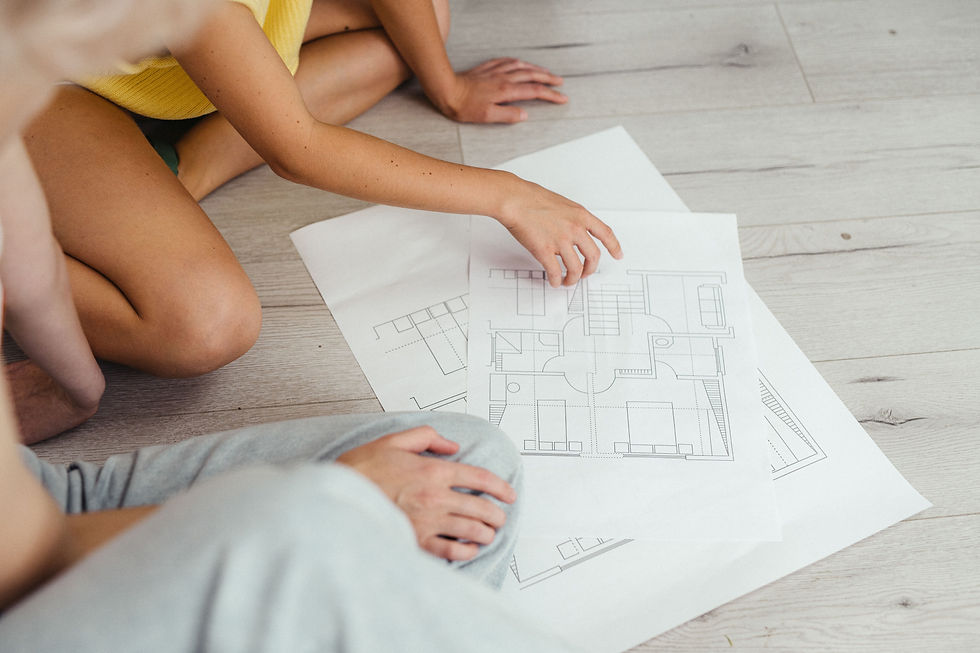a child's hand next to an adult looking at house building plans