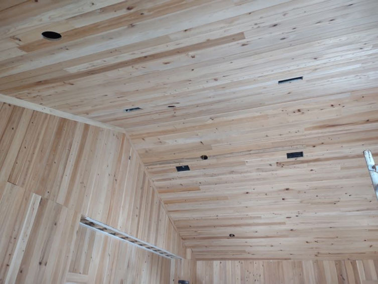 Covered room finished in knotty tongue-and-groove wood planks on the walls and ceiling