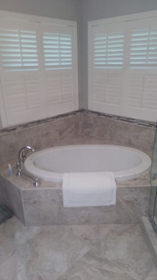 freshly grouted tiles around a large oval built in tub