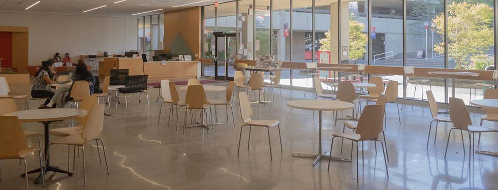 Large open room with tables and chairs. Wall of floor to ceiling windows.