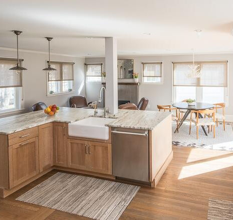 Greater Boston kitchen remodel with wood cabinetry, light countertops, pendant lighting, and open dining area by Morse Constructions