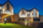 Modern houses with bright windows and outdoor lighting at night