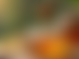 Raw honey dripping from wooden dipper into jar