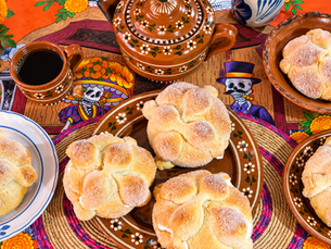 “Pan de muerto tradicional acompañado de café y cerámica mexicana sobre una mesa decorada para Día de Muertos.”
