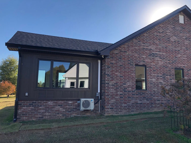 Custom sunroom addition designed by custom home designers in West Tennessee, blending seamlessly with the existing home while creating a bright, inviting living space.