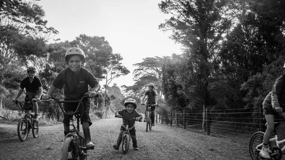 five children ride their bikes toward the camera