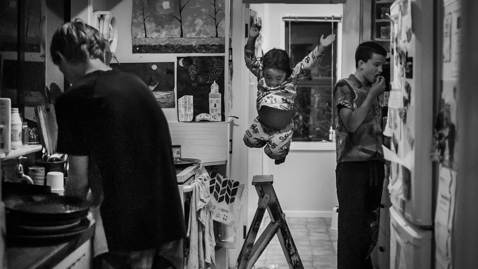 boy jumps off ladder in kitchen