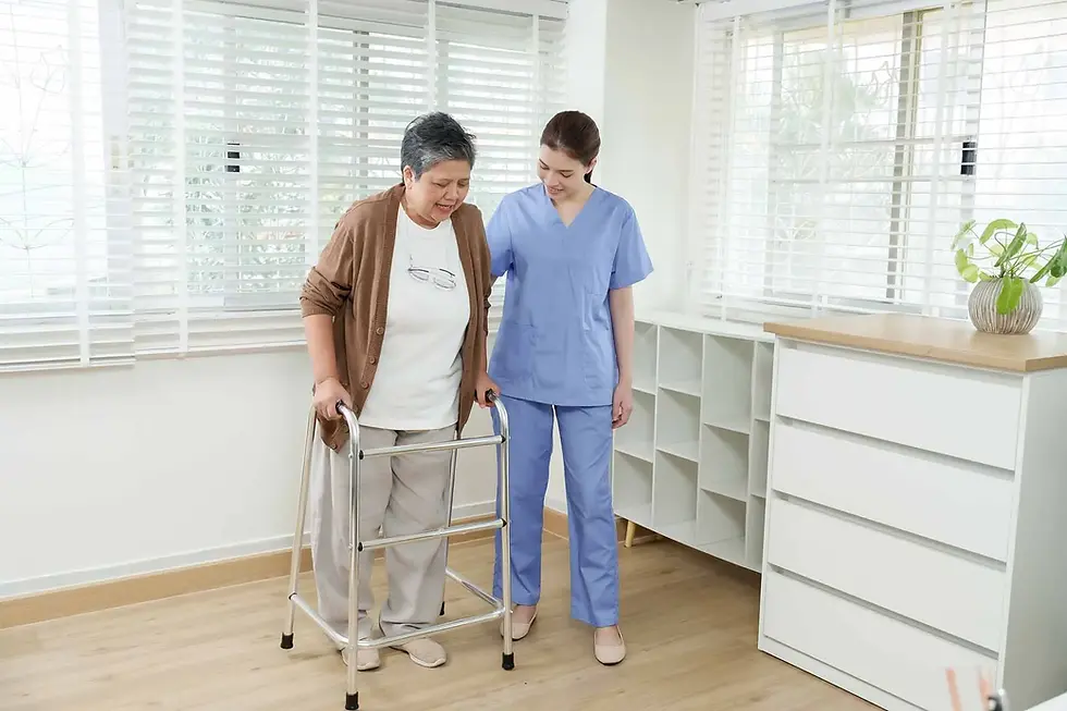 Physiotherapist supporting an older woman using a walking frame during home rehabilitation after a fall