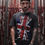 Thumbnail: Lee Johnston Wearing Red Torpedo Brit Punk Men's Anthracite Tee Showing Front Design