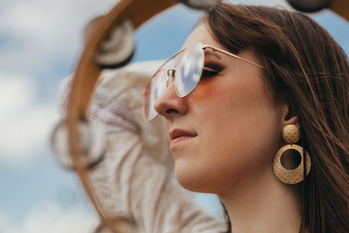 Daisy Jones and The Six Inspired Photoshoot | A girl dressed as Daisy Jones with a tambourine and a guitar | 70's style | Hippie and Free spirit | 70's style in a field
