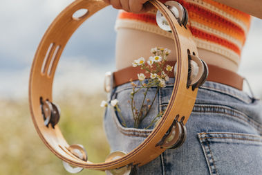 Daisy Jones and The Six Inspired Photoshoot | A girl dressed as Daisy Jones with a tambourine and a guitar | 70's style | Hippie and Free spirit | 70's style in a field | 

