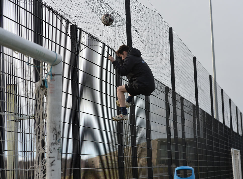 Christopher McKeown scales the fence to retrieve the ball