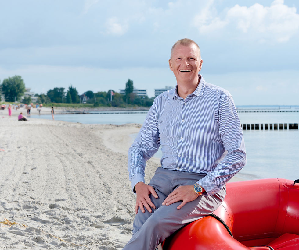 Matthias Prehm am Strand auf rotem Rettungsboot