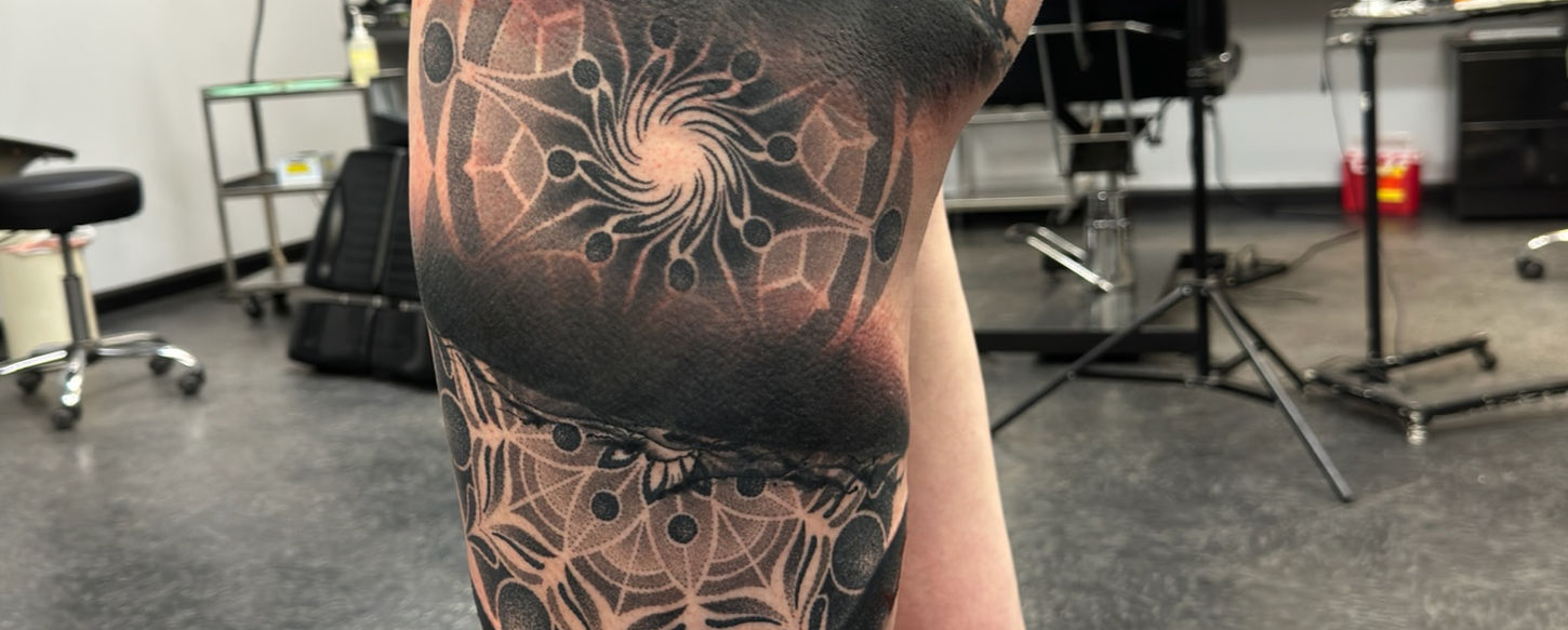 left leg tattoo of hexagon and multiple different shape designs