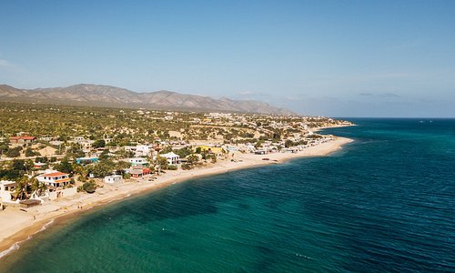 Coast of La Ventana lined with houses and greenery.