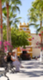 Two women sitting on a bench in front of the church of Todos Santos, Mexico. 