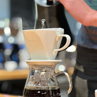 Hot water being poured into a single serve coffee maker at Cafe DoceCuarenta in Cabo Mexico.