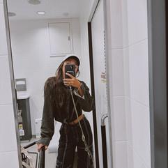 Woman taking a selfie in a mirror in the airport bathroom. 