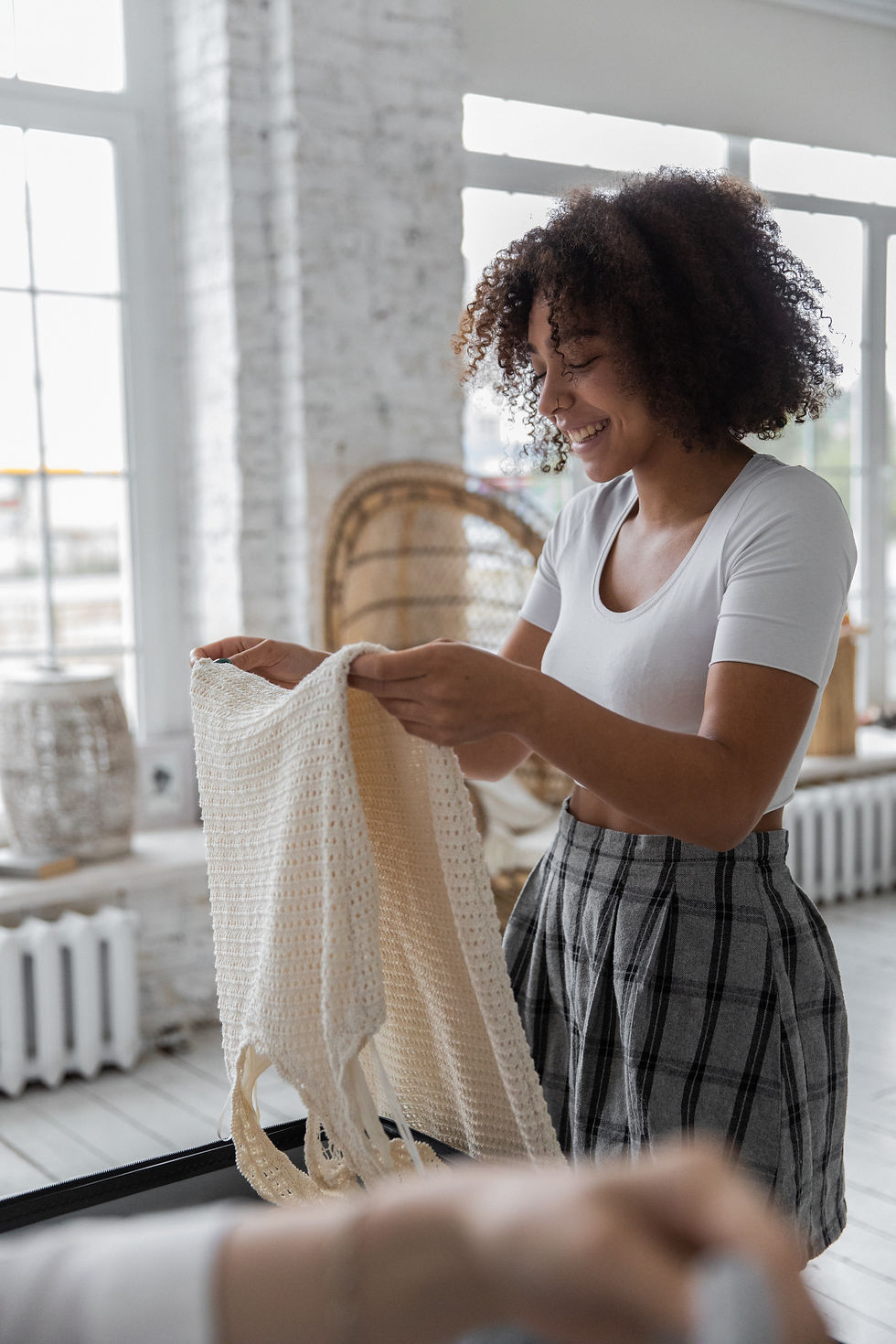 Woman packing clothing onto a piece of luggage.