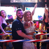 Smiling man and woman in a party boxing ring, woman pointing