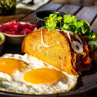 Quesabirria served with sunny side up eggs, and garnishes from Hoja Santa in Cabo, Mexico.