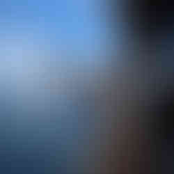 Woman in a white bikini wearing a straw cowboy hat with a long wedding veil, posing on the side of a yacht in Cabo San Lucas.