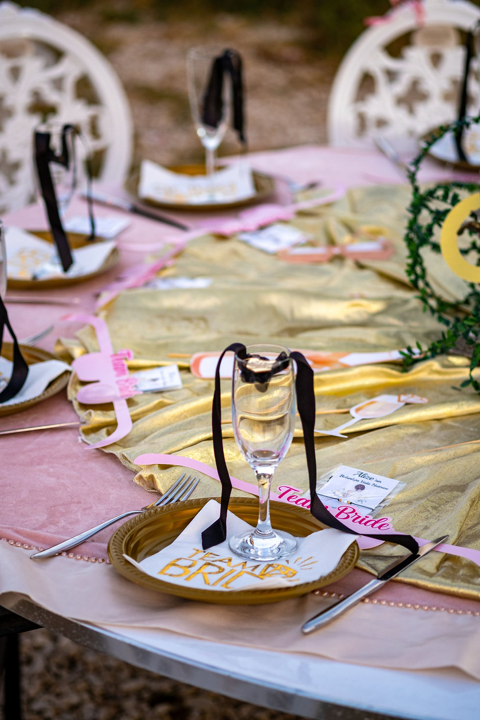 A table decorated in pink, gold and black for a bachelorette dinner.
