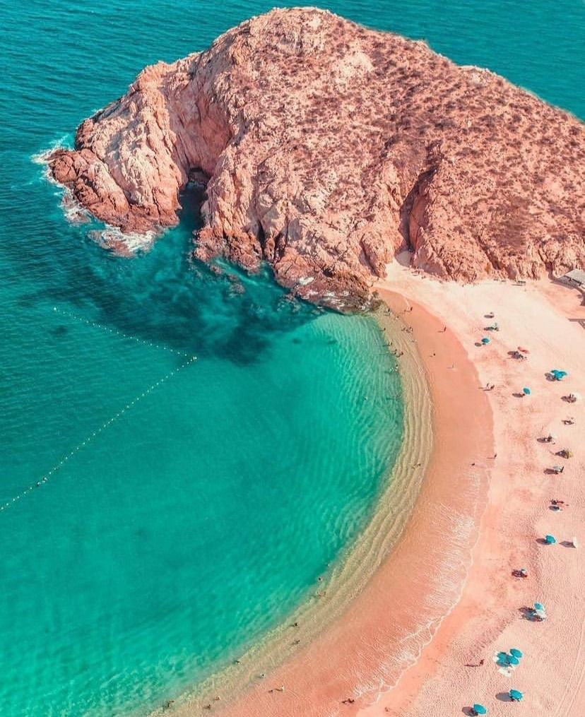 Bird's eye view of Santa Maria Beach with umbrellas scattered in the sand.
