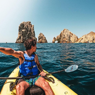 Man taking a selfie on a kayak in front of The Arch.