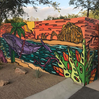 Mural of the Arch of Cabo with a sunset, a whale, and some greenery.