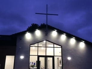 Church building in the night with a cross on the roof