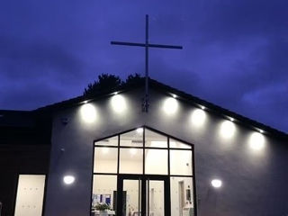Church building in the night with a cross on the roof