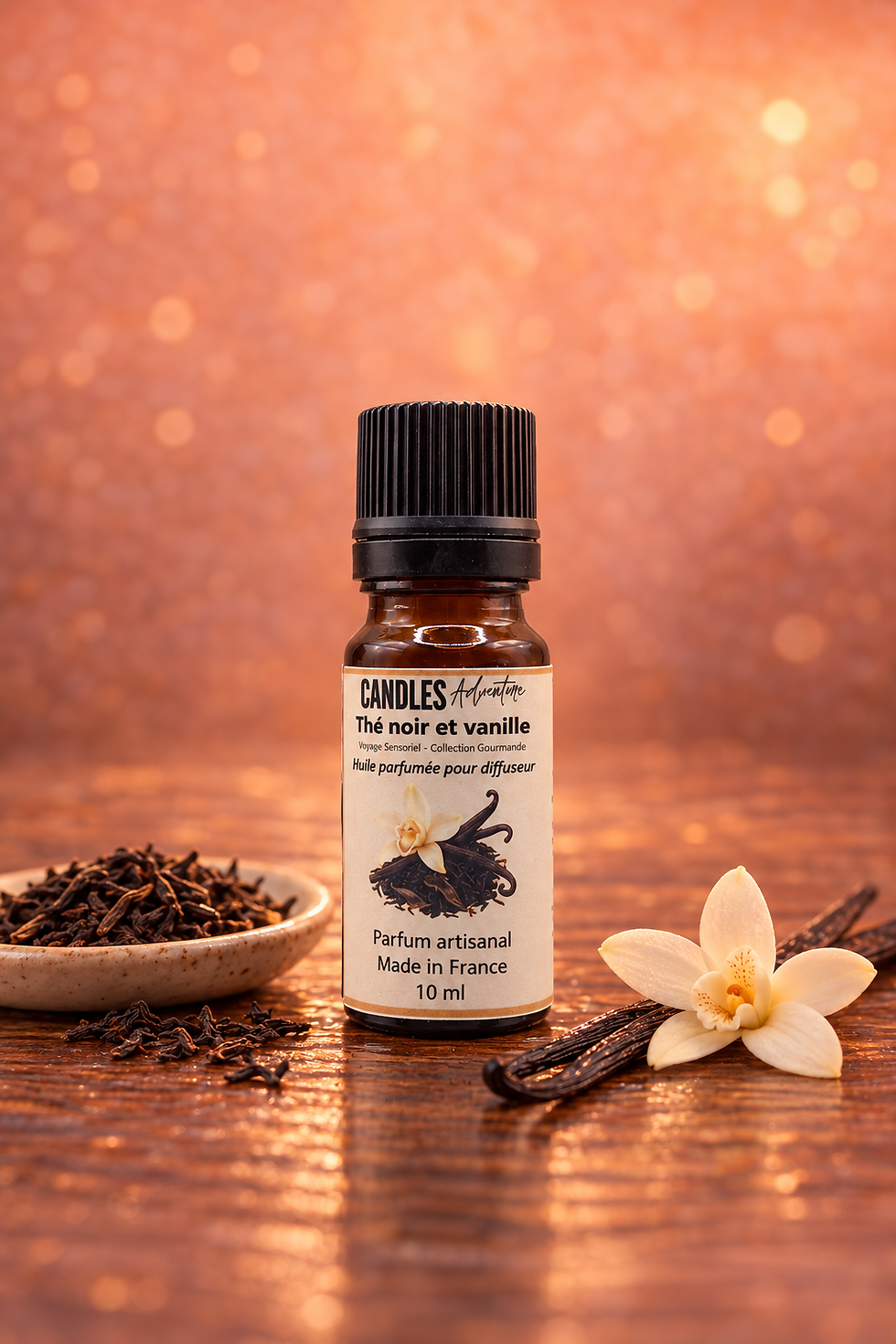 Flacon d’huile parfumée Thé Noir et Vanille 10 ml, avec feuilles de thé, gousses de vanille et fleur sur bois.