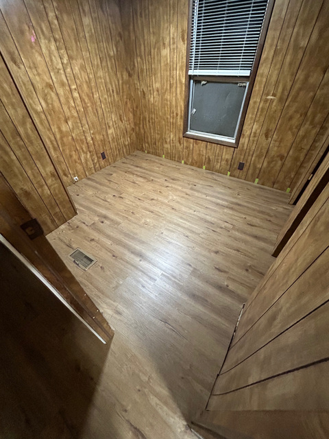 A photograph displaying a section of wooden flooring, emphasizing its smooth surface and intricate wood grain details.