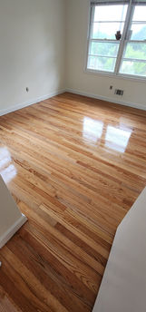 A smooth wooden floor with a natural finish, highlighting the intricate patterns of the wood grain.
