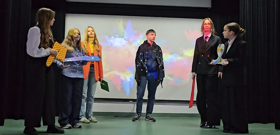 Side-angle view of students performing a scene about inclusion for classmates in a school hall.