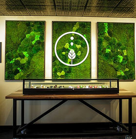a photo of a wooden table with a floral art piece on the wall behind it