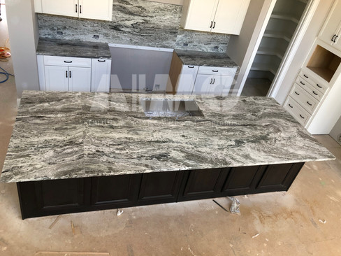 Modern kitchen featuring a Fantasy Brown Marble waterfall island and countertops by Aravali Marbles, showcasing elegant natural veining and exceptional durability.