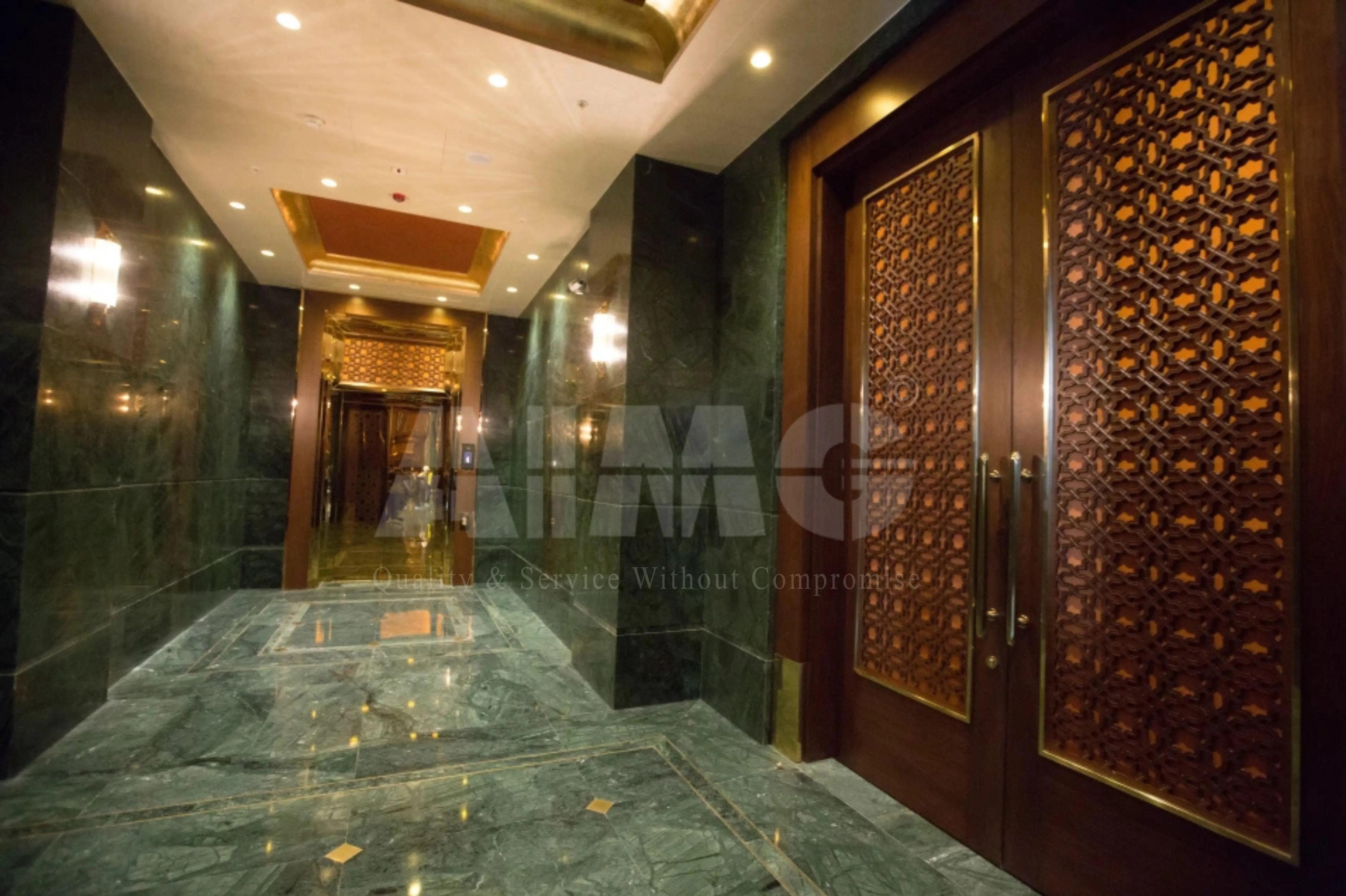 Luxury hotel lobby featuring premium green marble flooring and wall cladding by Aravali Marbles with polished emerald-green natural stone and elegant architectural design.
