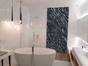 Bathroom interior featuring a feature wall clad in Black Markino Granite with dramatic white veining, supplied by Aravali India Marbles & Granites.