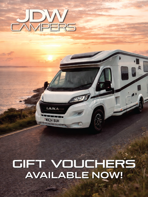 A JDW Campers Motorhome driving along the coast with a sunset falling in the background.